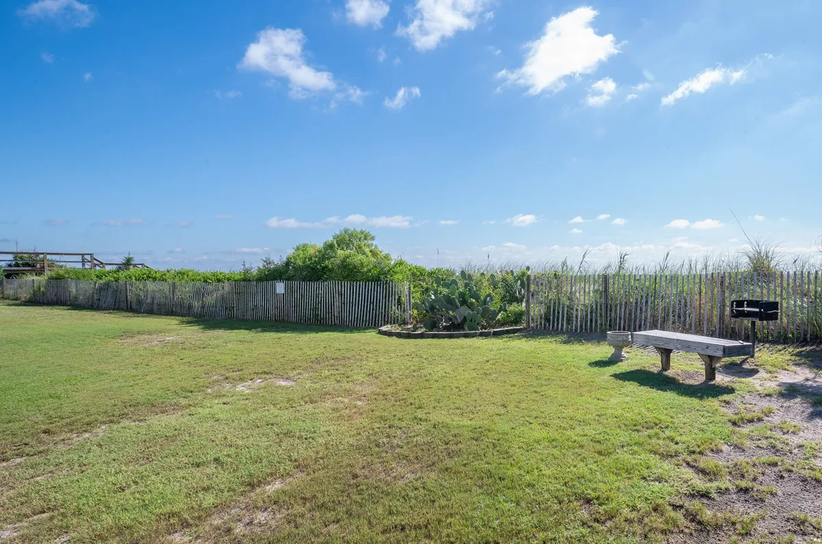 The photo highlights a beautifully landscaped garden area with a bench and surrounding greenery, offering a peaceful spot for relaxation or quiet conversation. The space feels secluded and intimate, ideal for tranquil strolls or enjoying the natural setting together.