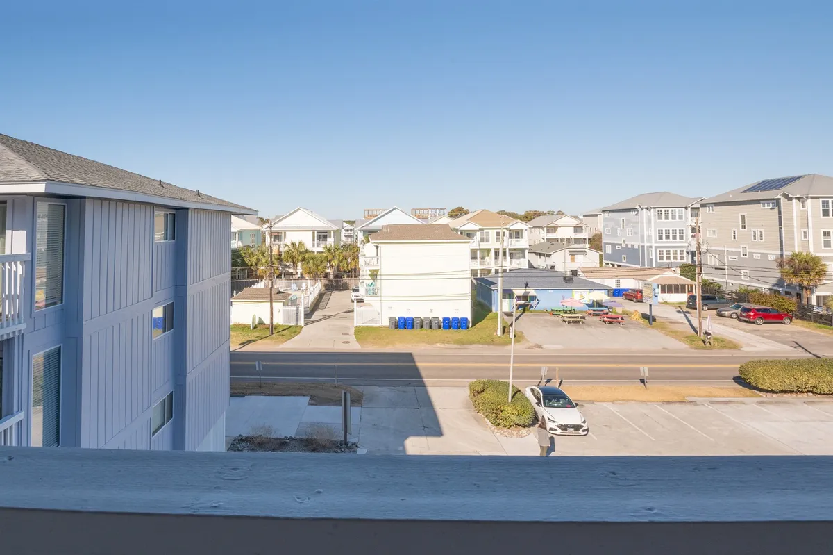 A scenic view featuring palm trees, nearby buildings, and a peaceful street scene, likely near the beach. The setting evokes the feeling of exploring the local neighborhood or strolling to nearby attractions, with hints of sunrise or sunset lighting.